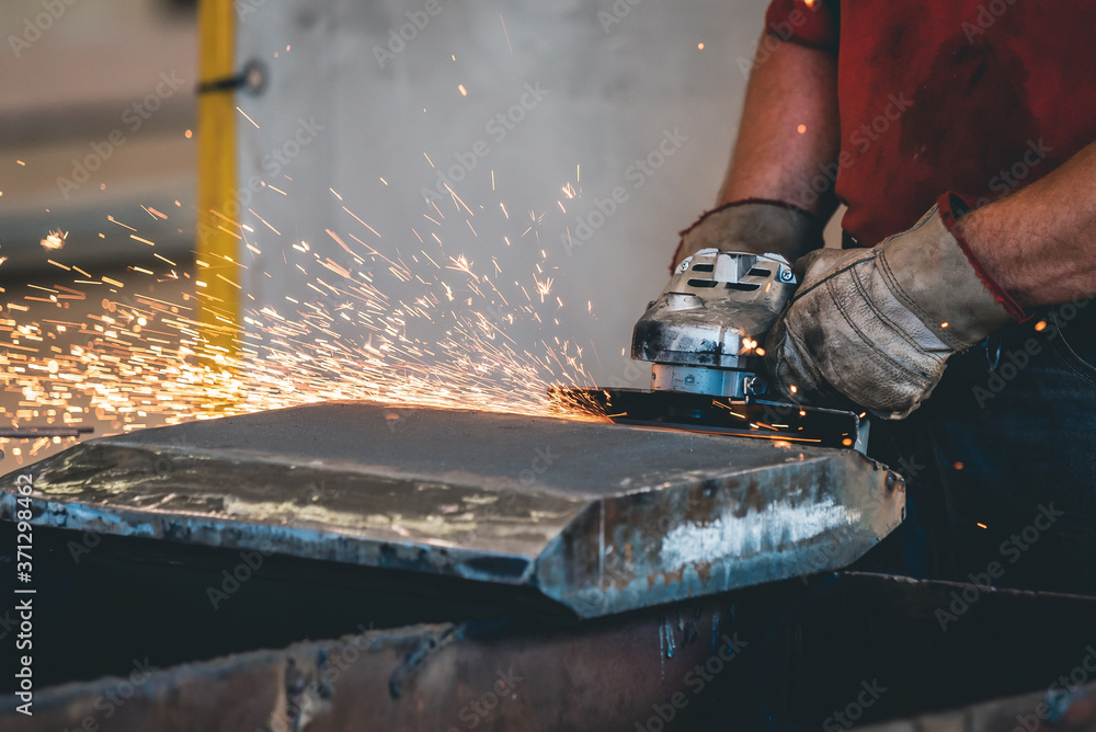 Hands of workers grinding steel in the metal industry