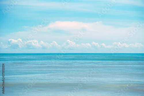 Beautiful white clouds on blue sky over calm sea, Tranquil sea harmony of calm water surface.