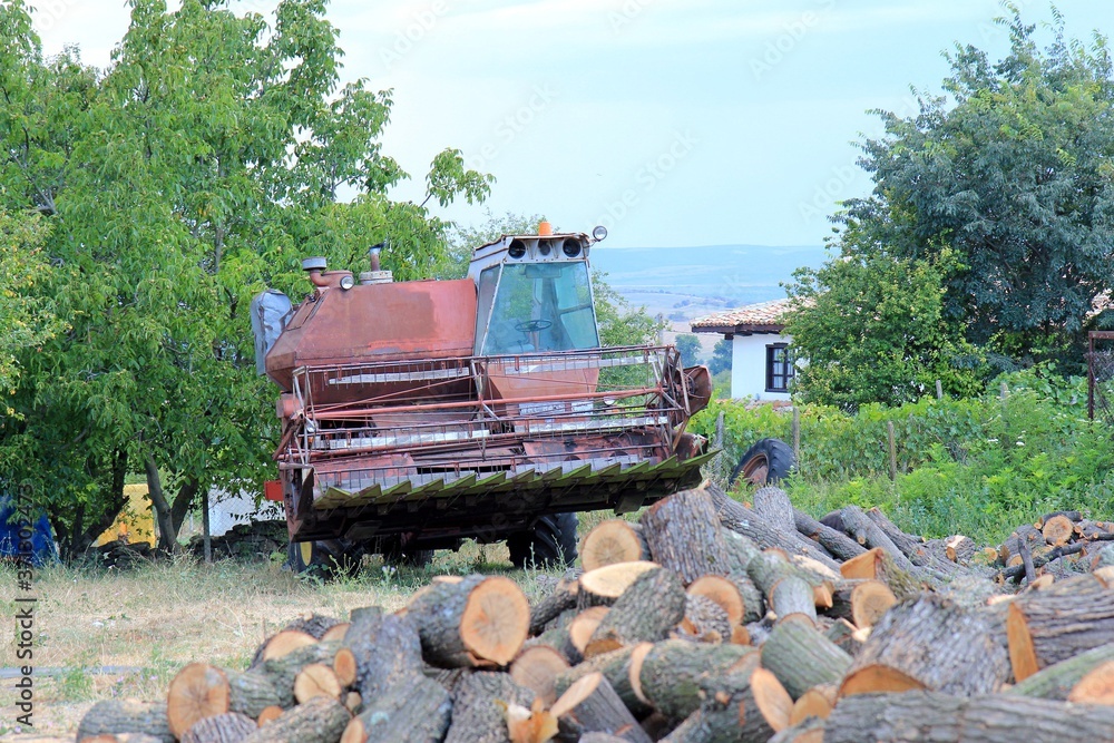 Combine harvester in the village yard in Bulgaria in the evening Combine harvester in the village yard in Bulgaria in the evening