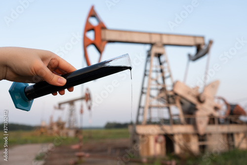 oil industry. a test tube with crude oil in the hand of an engineer