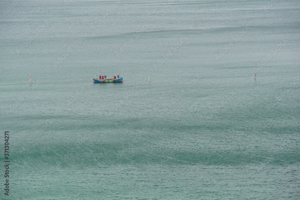 Fishermen by boat near fishing nets