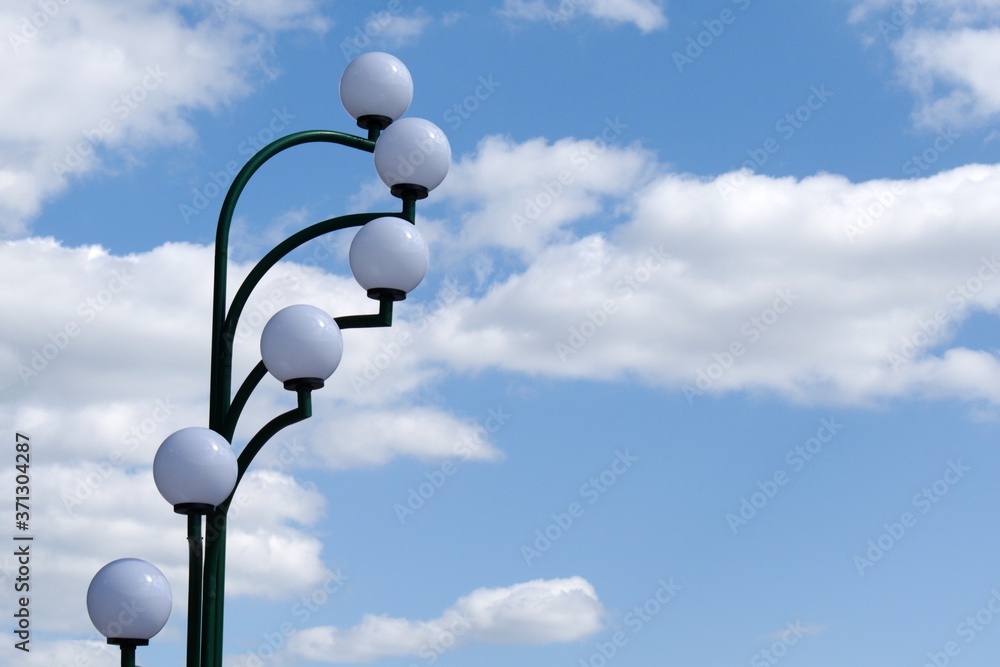 white round lights on blurred sky background with white clouds