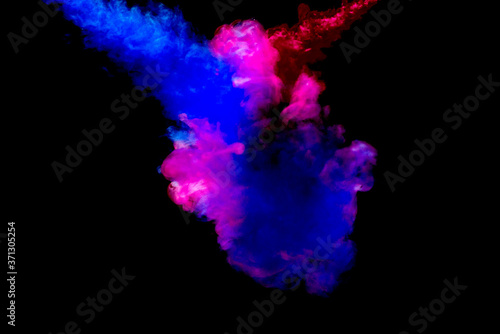 A cloud of pink and blue paint released into clear water. Isolate on a black background.