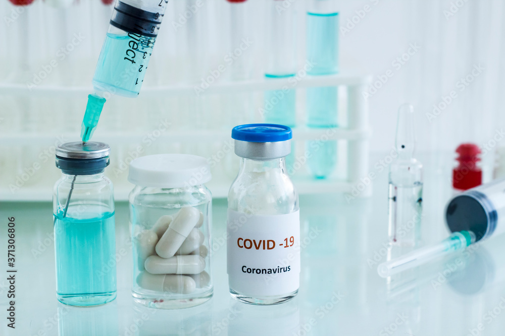 Mini medicine glass bottle and injector with medical materials on the glass table.Conceptual image of vaccine works in the laboratory. Mini medicine glass bottle and injector with medical materials on the glass table.Conceptual image of vaccine works in the laboratory.