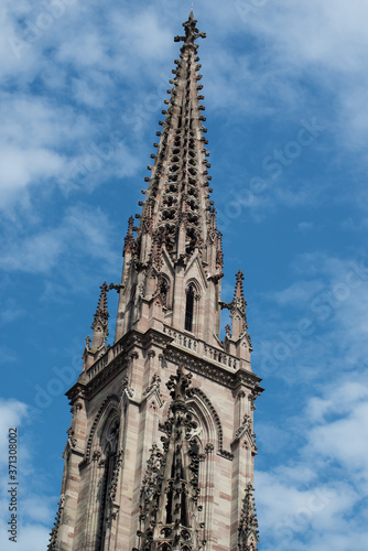 closeup of tower bell of the St Etienne protestant temple on blue cloudy sky background in Mulohuse - France