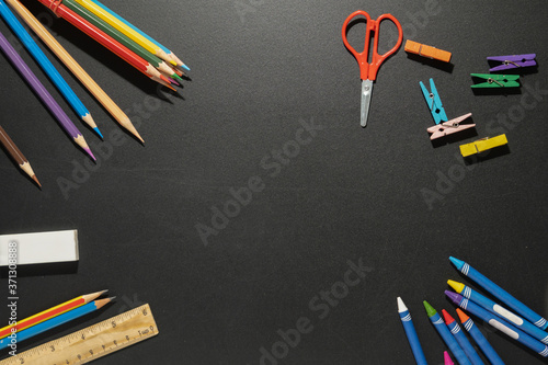 School supplies for background.stationery group of items pencils, pens,ruler,color on blackboard.Back to school concept.