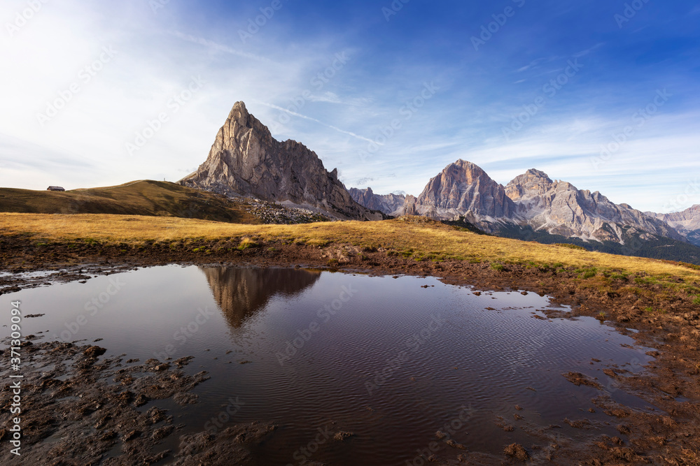 Italian Dolomites, Passo Giau - view of the peaks of the Dolomites, which are reflected in a small mountain lake at sunset with beautiful light.