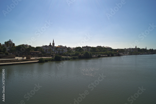 Vistas del río Guadalquivir a su paso por el Muelle la Sal y de la avenida Paseo Colón en Sevilla desde el puente de Triana (Andalucía, España).
