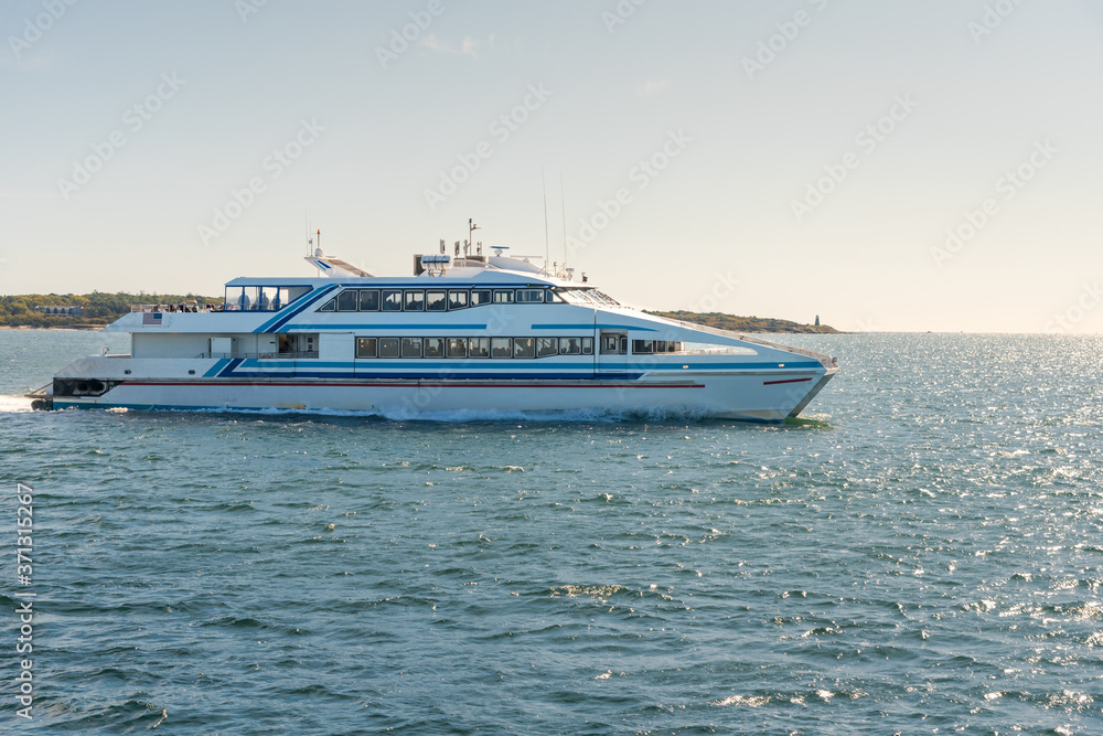 Passenger high-speed ferry leaving a harbour on a sunny autum day Passenger high-speed ferry leaving a harbour on a sunny autum day
