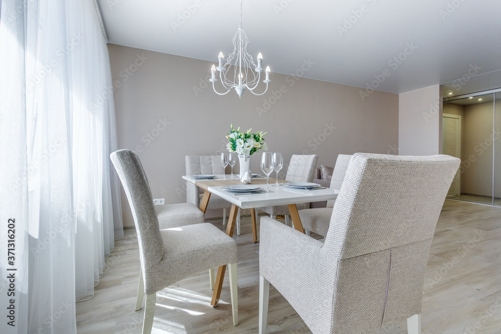served table with a bouquet of roses in interior of modern luxure guest room in studio apartments in minimalistic style served table with a bouquet of roses in interior of modern luxure guest room in studio apartments in minimalistic style