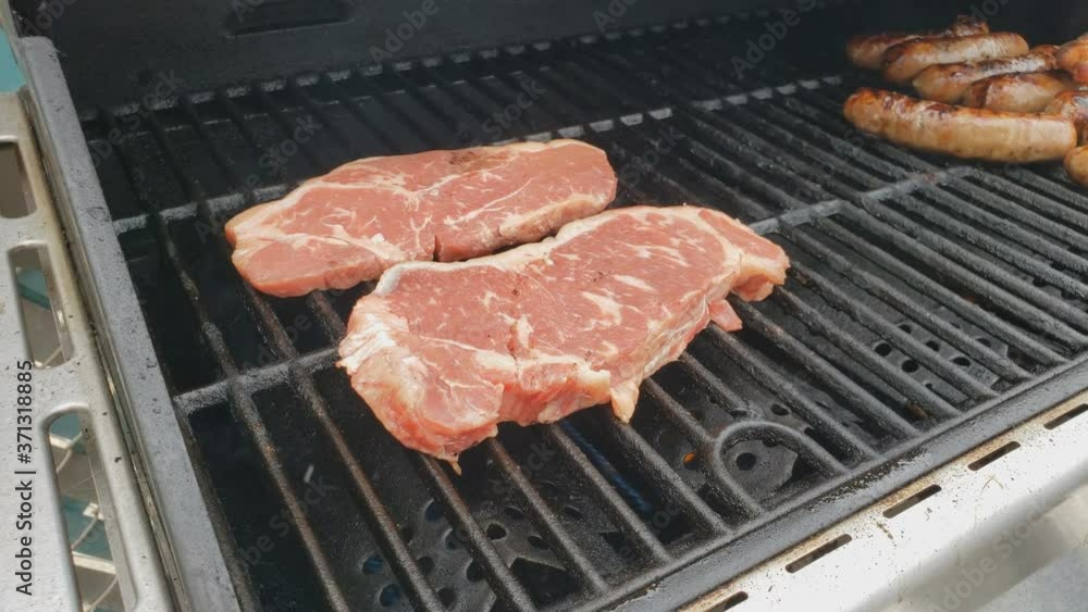 Home cooking - Two New Your Strip steaks being grilled just after being placed on griddle. Home cooking - Two New Your Strip steaks being grilled just after being placed on griddle.
