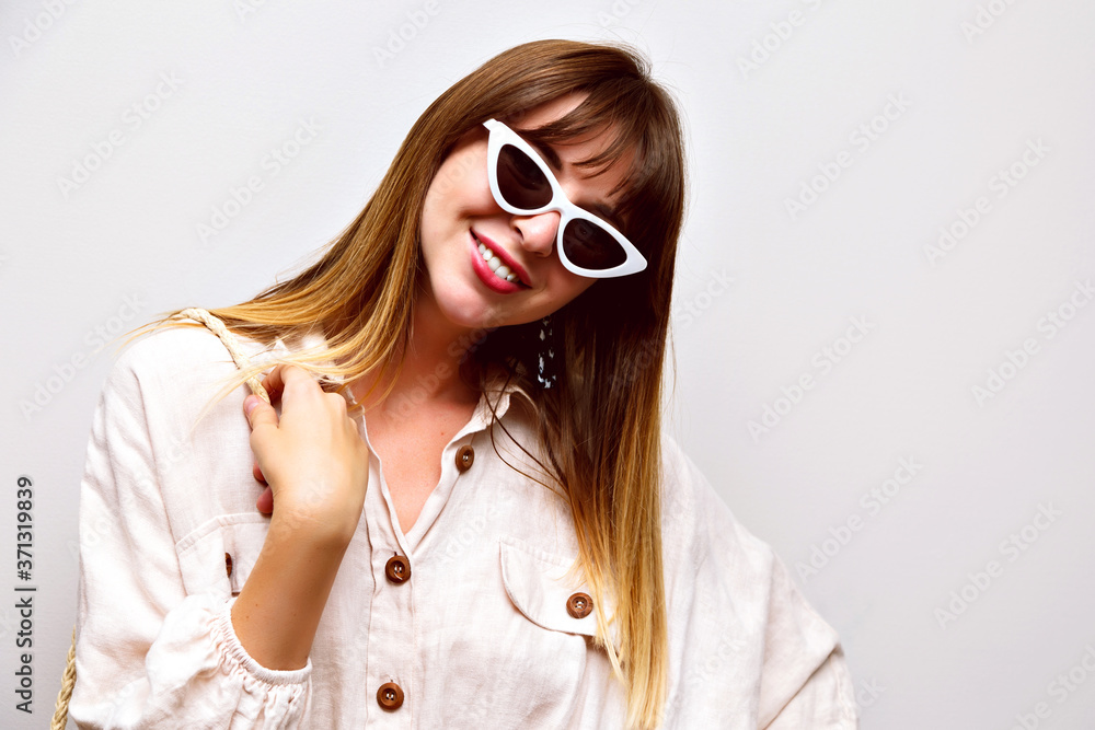 Cute indoor studio portrait of pretty hipster woman wearing boho shirt and vintage cat eye sunglasses,toned soft colors colors, smiling face. Cute indoor studio portrait of pretty hipster woman wearing boho shirt and vintage cat eye sunglasses,toned soft colors colors, smiling face.