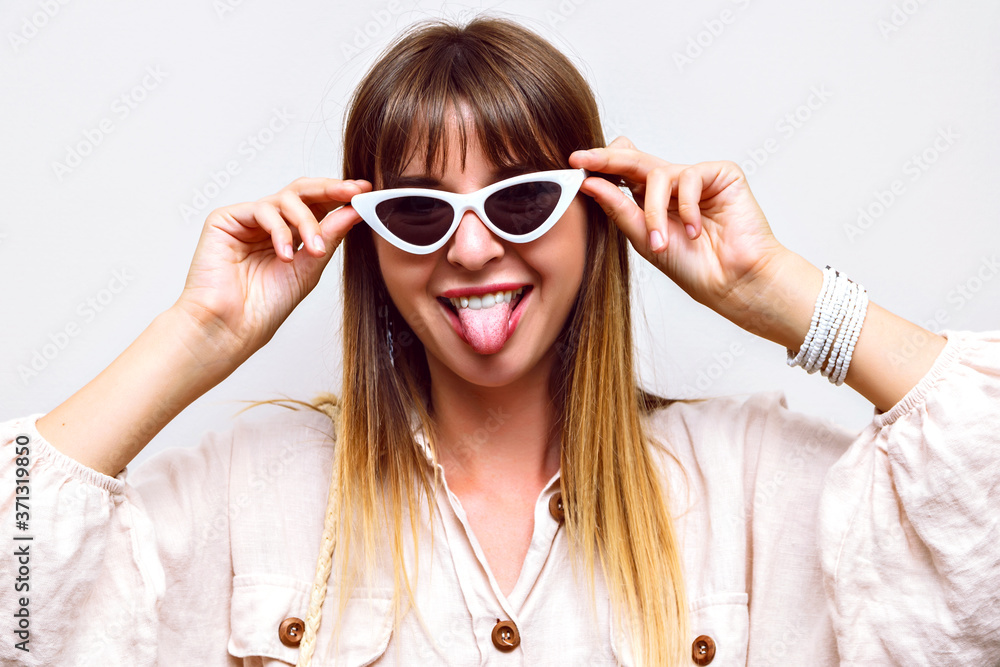 Crazy funny portrait of woman showing long tongue, making grimace, summer trendy look. Crazy funny portrait of woman showing long tongue, making grimace, summer trendy look.