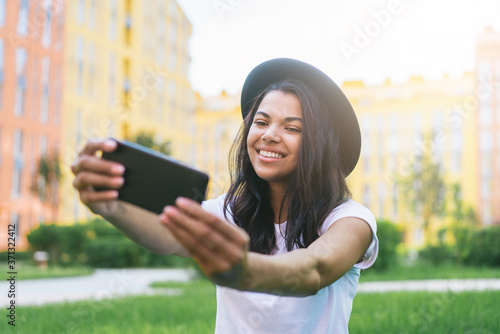 Cute african american girl taing selfie on her mobile phone outdoors photo