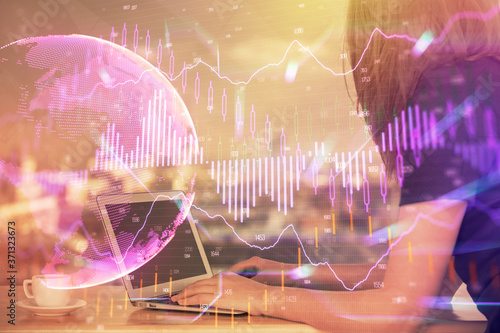 Double exposure of businesswoman hands typing on computer and forex chart hologram drawing. Financial analysis concept.