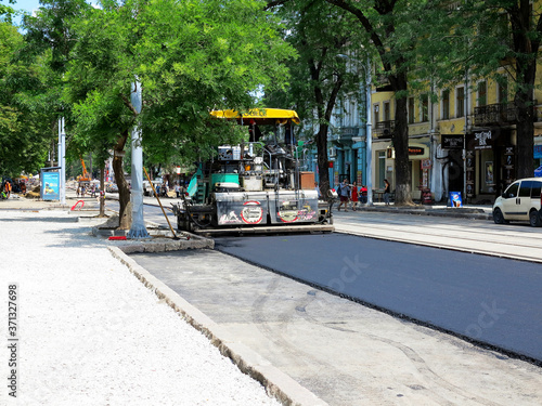 Odessa, Ukraine - 17 July 2017: Machine for laying asphalt linear road construction equipment. Laying asphalt. Construction and repair of city roads.