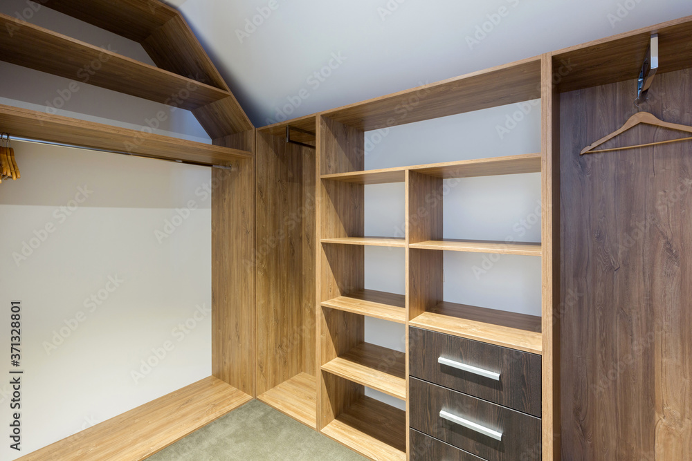 Fototapeta premium Empty storage room wardrobe cloakroom interior organization with shelving, hanging rails and shoe racks