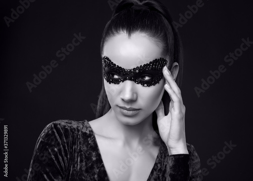 Charming elegant brunette woman in purple dress and sequins mask