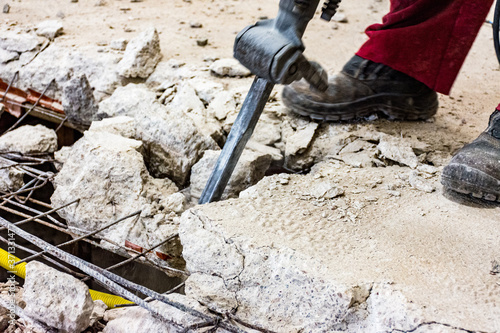 Trabalho árduo de demolição de estrutura de concreto com ferramenta.