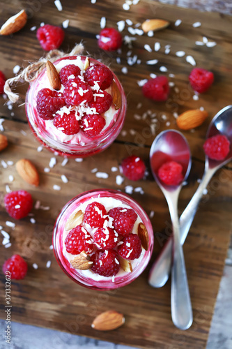Selective focus. Healthy dessert in jars with curd cream and raspberries.