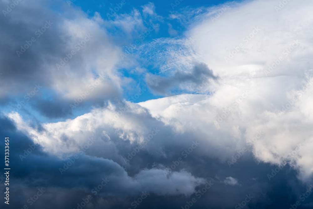Dramatic thunderstorm clouds floating in blue sky before rain. Majestic cloudscape background, natural weather meteorology concept. Dramatic thunderstorm clouds floating in blue sky before rain. Majestic cloudscape background, natural weather meteorology concept.