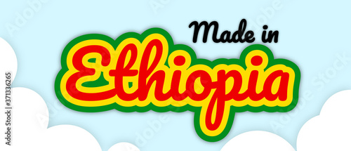 Bold stroke text style  Made in Ethiopea  vector illustration. Text in country flag colours  floating on editable removable sky with clouds background.