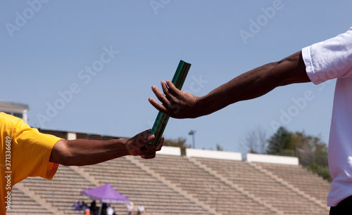 Two athletes practice baton pass photo