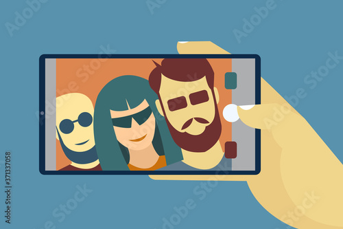 Hand holds a mobile showing people taking selfie