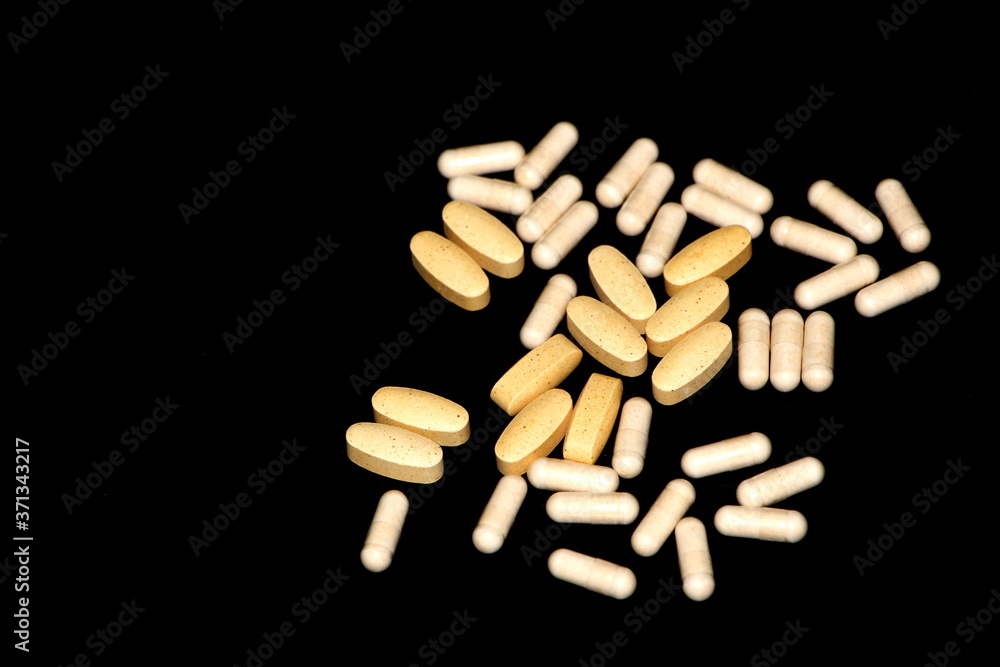 The assorted pain killer pills / vitamin supplements on the black background. The assorted pain killer pills / vitamin supplements on the black background.