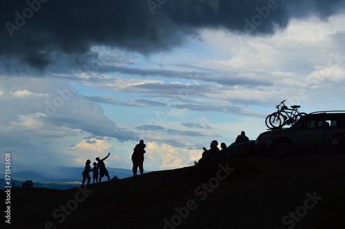 silhouette of a cyclist a couple and a litlle family over the pedra grande atibaia