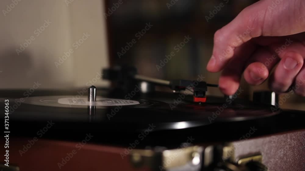 Hand placing the Needle of a Record Player onto a Spinning Vinyl Record. Close-Up. Hand placing the Needle of a Record Player onto a Spinning Vinyl Record. Close-Up.