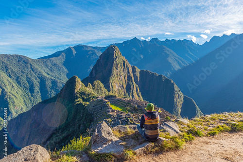 Tourist contemplating the Machu Picchu inca ruin at sunrise, Cusco, Peru. photo
