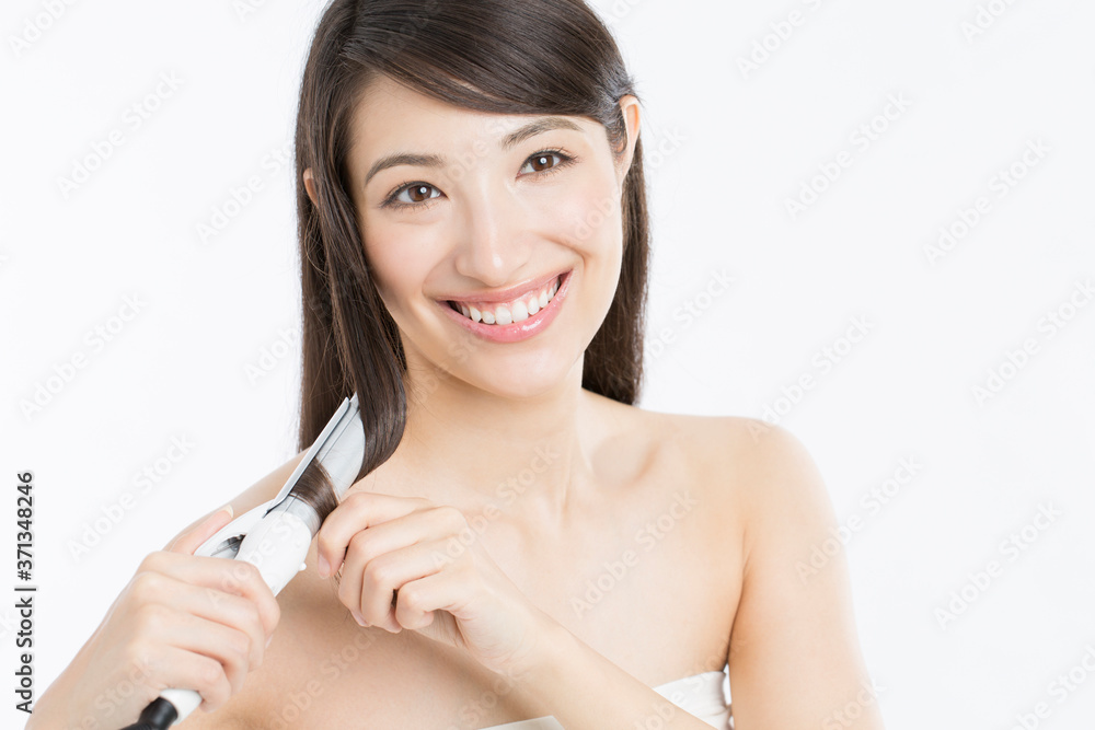 ヘアアイロンをする女性 ヘアアイロンをする女性