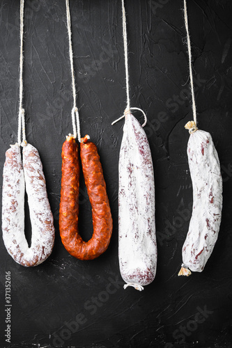Traditional spanish sausages fuet and longaniza on black background