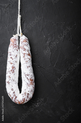 Fuet salami wurst on black background, topview with space for text
