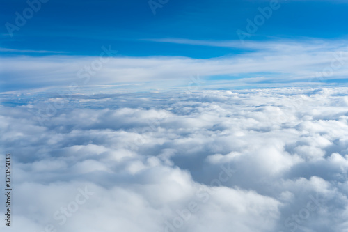 Fluffy clouds top view of the airplane. Heavenly landscape