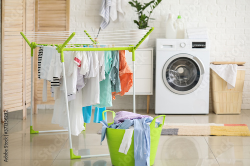 Schilderij op canvas Clean clothes hanging on dryer in laundry room