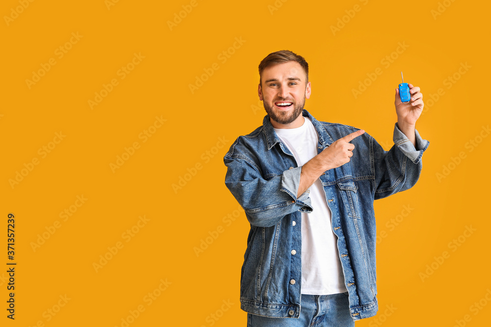 Happy young man with car key on color background Happy young man with car key on color background