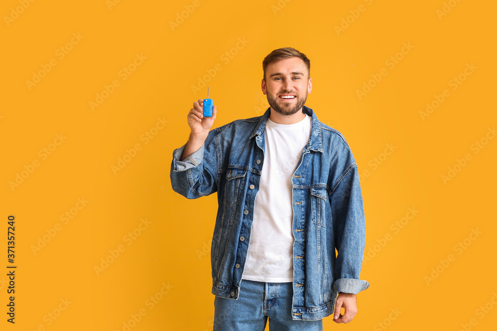 Happy young man with car key on color background Happy young man with car key on color background