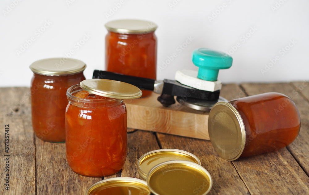 Homemade jam for future use. Amber apple jam in jars on a wooden table with a white background. Homemade jam for future use. Amber apple jam in jars on a wooden table with a white background.