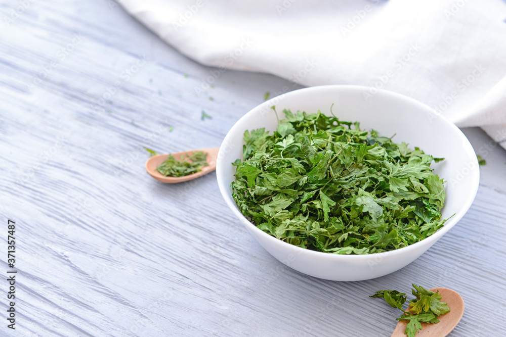 Bowl with dry parsley on table Bowl with dry parsley on table
