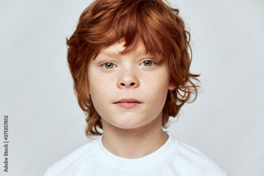 Redhead boy face closeup freckles on face cropped view gray background Redhead boy face closeup freckles on face cropped view gray background