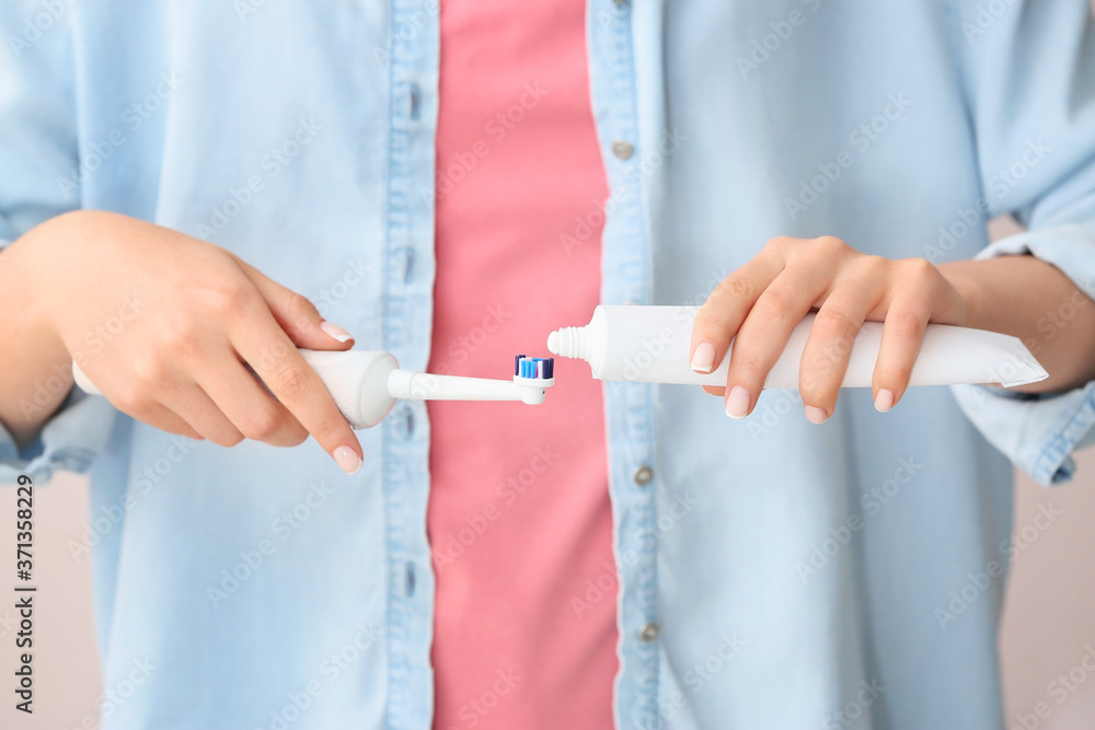 Woman with electric toothbrush and paste, closeup