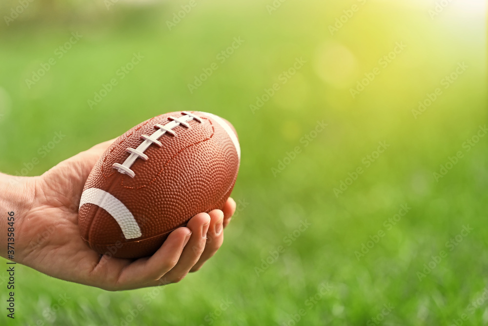 Male hand with rugby ball outdoors Male hand with rugby ball outdoors