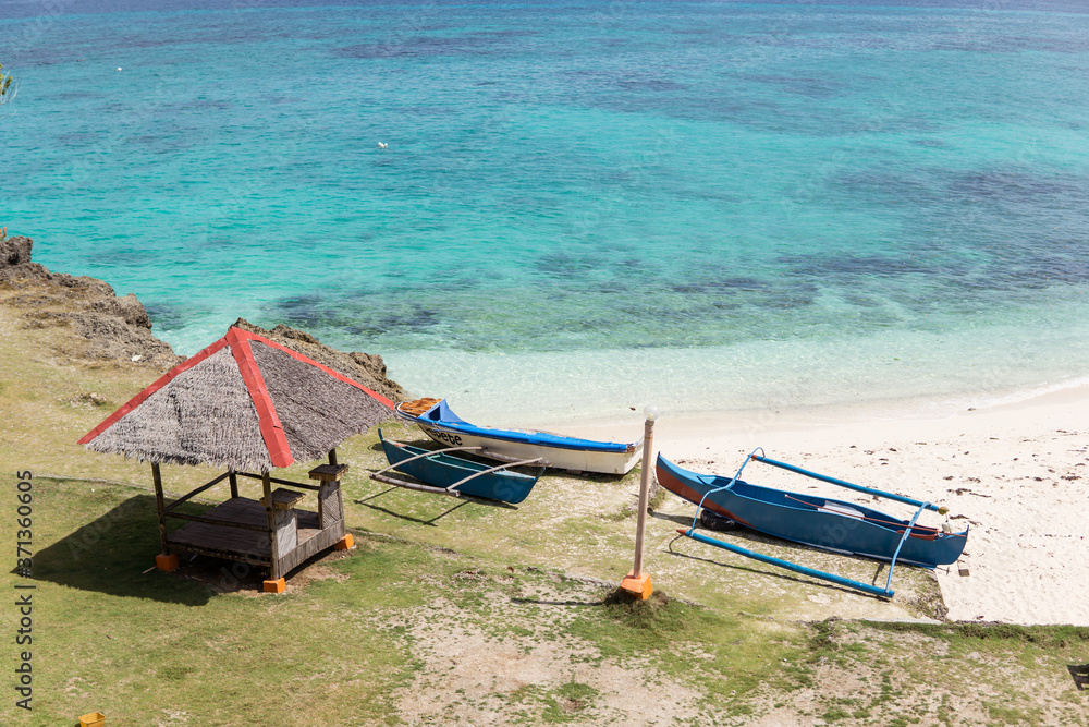 beautiful white sand beach and turquoise water with wooden boat on the sand