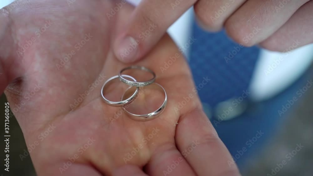 three wedding rings, correct their finger on the hand of a man. close-up. three wedding rings, correct their finger on the hand of a man. close-up.