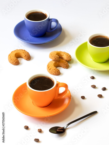 Colored cups of coffee with coffee beans on a white background.