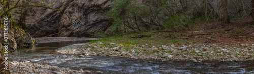 flowing creek with rocks stones while hiking panorama