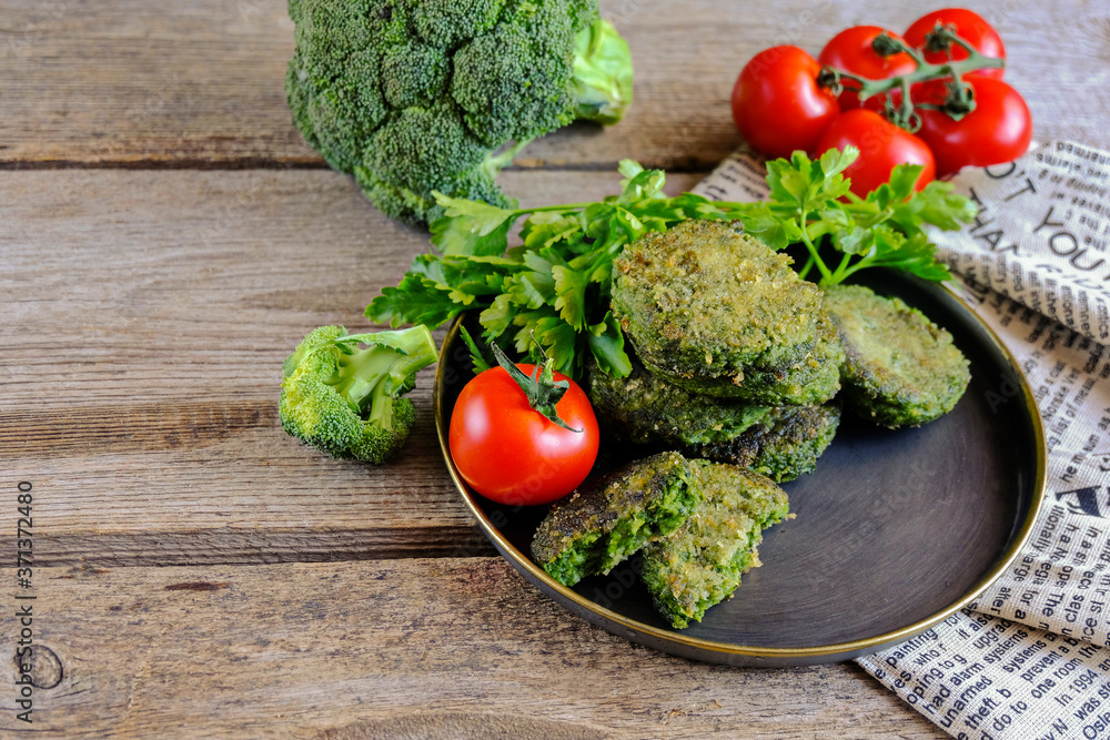 Fried vegetarian patties on a plate with the tomatoes. Healthy vegetarian or vegan food. On a wooden table. Fried vegetarian patties on a plate with the tomatoes. Healthy vegetarian or vegan food. On a wooden table.