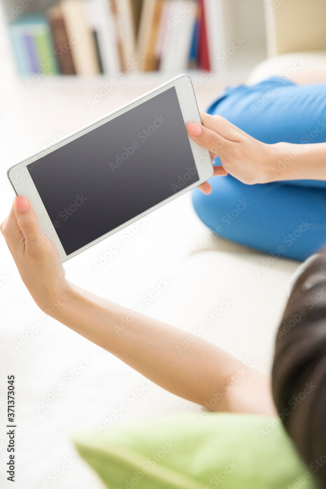 寝転んでタブレットPCを見る女性 寝転んでタブレットPCを見る女性